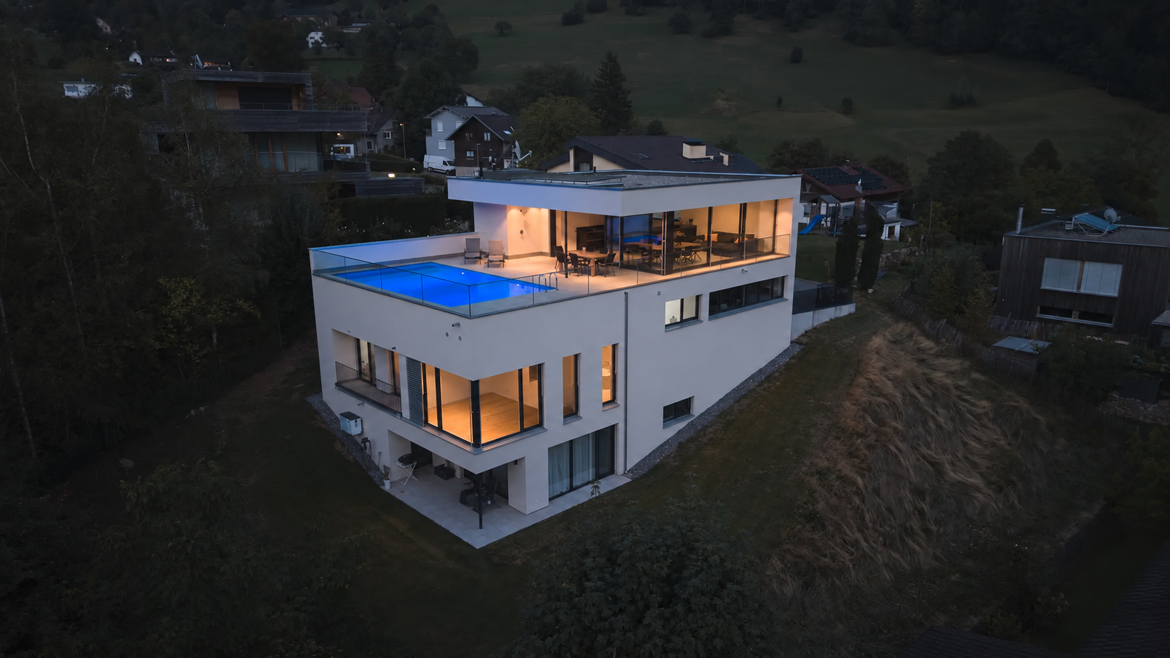 Beleuchtete Villa am Abend aus der Luft